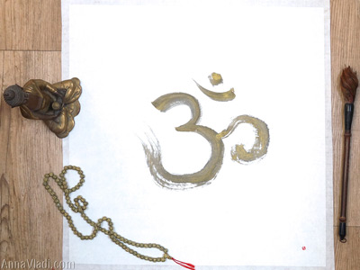Om — handwritten calligraphy in golden ink